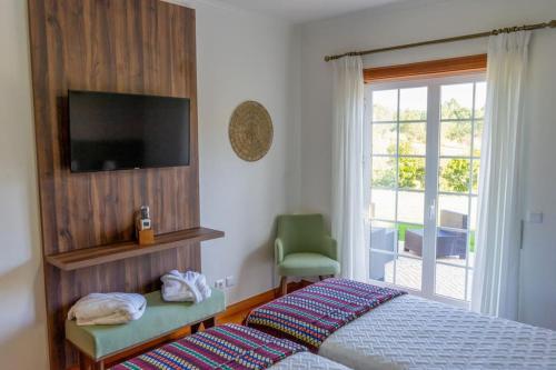 Quinta Vale Lameiros的一间卧室配有一张床、一台电视和一个窗口