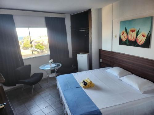 福塔莱萨Villa Del Sol Hotel Fortaleza的一间卧室配有一张床、一张桌子和一个窗户。