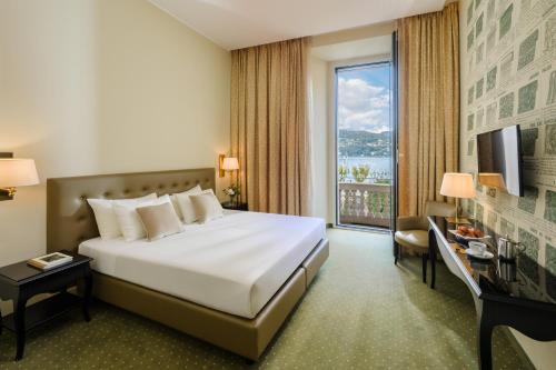 科莫Palace Hotel Lake Como的酒店客房设有一张床和一个大窗户