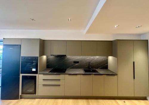 比雷埃夫斯BlueMotion - TwinBedroomPortApartment 3B的厨房配有白色橱柜和蓝色冰箱。