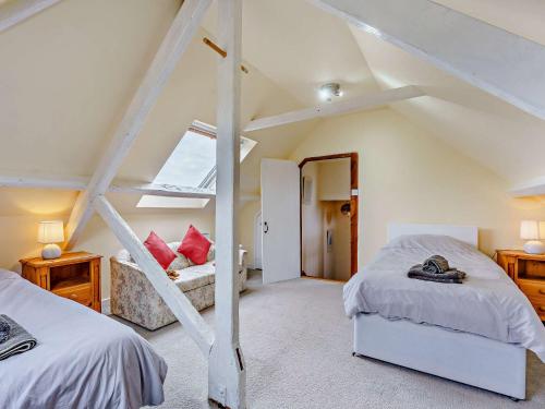 迪姆彻奇3 bed property in Aldington 54088的阁楼卧室设有两张床和楼梯。