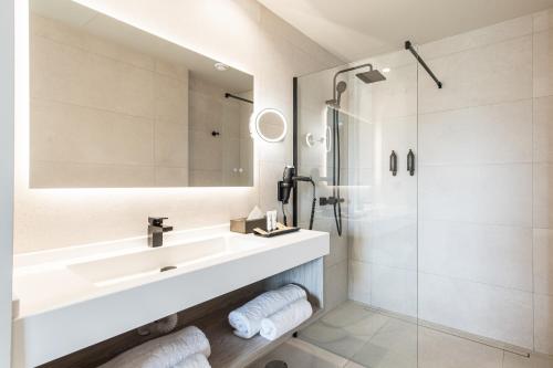 圣米格尔德阿沃纳Amarilla Golf Residences的白色的浴室设有水槽和淋浴。