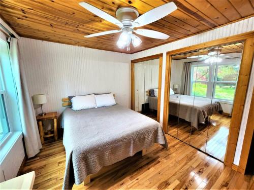 特拉弗斯城Creekside Hot Tub-Walk to Beach-Uniquely Northern的一间卧室配有一张床和吊扇