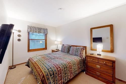 天使之火Gold Creek 206的一间卧室配有一张带梳妆台和镜子的床