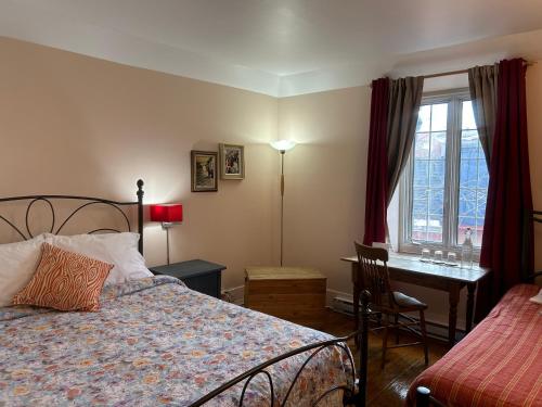 蒙特利尔镇中心阿德雷斯酒店的一间卧室配有一张床、一张书桌和一个窗户。