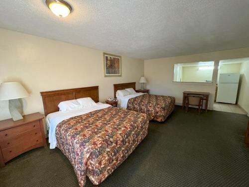 拉斯克鲁塞斯Big Chile Inn & Suites的酒店客房设有两张床和一张桌子。