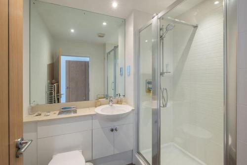 考斯2 Bed Harbour View Apartment的白色的浴室设有水槽和淋浴。