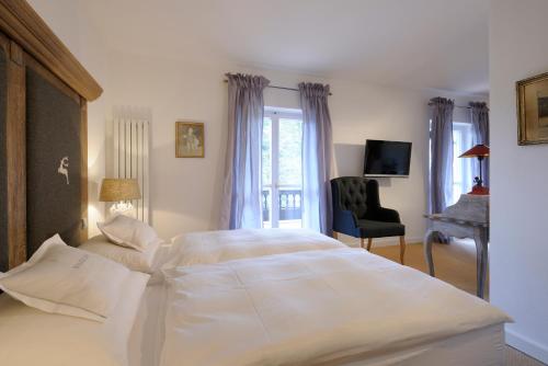巴特维塞Boutique Hotel Relais Chalet Wilhelmy的卧室配有一张白色大床和一把椅子
