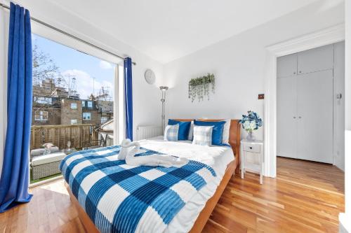 伦敦Blue Themed Luxury 1 Bedroom Balcony Flat, With Double Sofa Bed and Fast Wifi! Accommodates up to 6 Guests! Hyde Park!的一间卧室设有一张床和一个大窗户