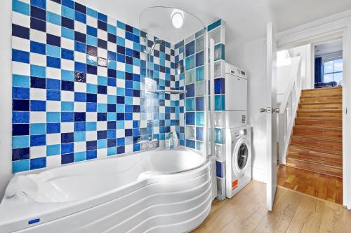 伦敦Blue Themed Luxury 1 Bedroom Balcony Flat, With Double Sofa Bed and Fast Wifi! Accommodates up to 6 Guests! Hyde Park!的带浴缸和洗衣机的浴室。