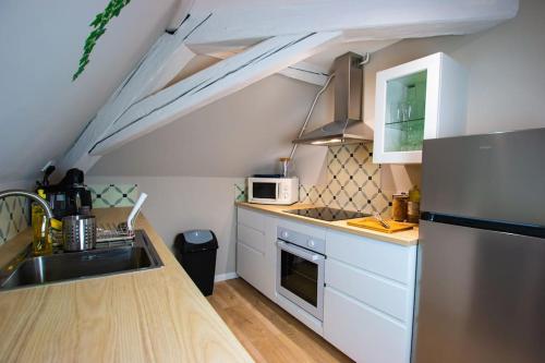 DorlisheimAu coeur du vignoble/centre ville的厨房配有水槽和炉灶 顶部烤箱