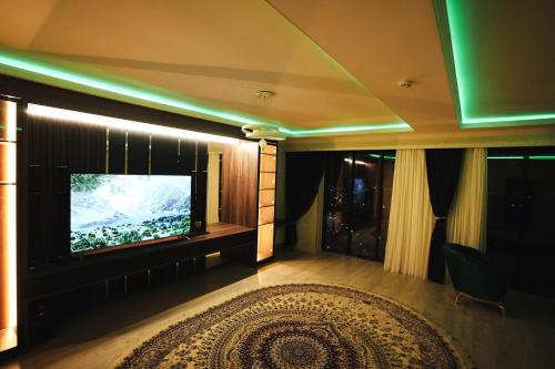 杜尚别BALAND HOTEL DUSHANBE的客厅配有平面电视和地毯。