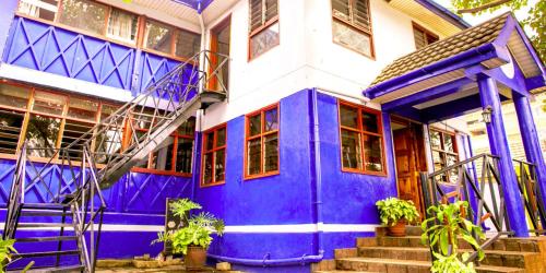 内罗毕Blue Hut Hotel的蓝色和白色的房子,有紫色的门