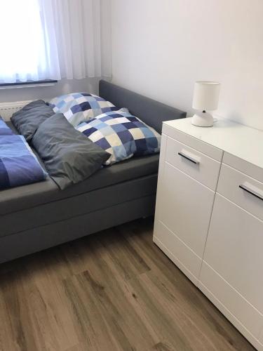 多特蒙德Wohnung in Dortmund Nähe Phönix See的一间卧室配有一张床和一个带灯的梳妆台