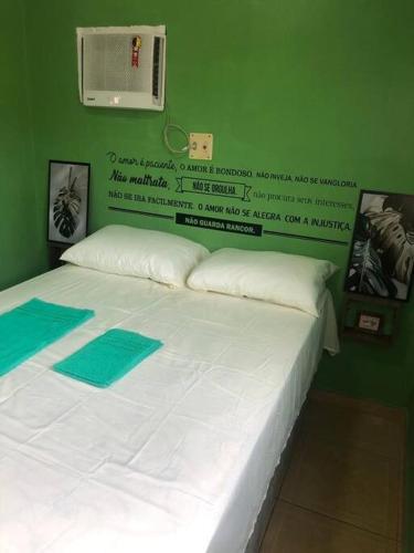 马瑙斯Apartamento Natureza Verde Manauara的一间卧室配有一张白色的床和绿色的墙壁