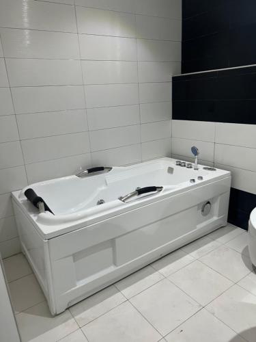 拉各斯Ikeja Airport View的带白色浴缸的浴室和卫生间