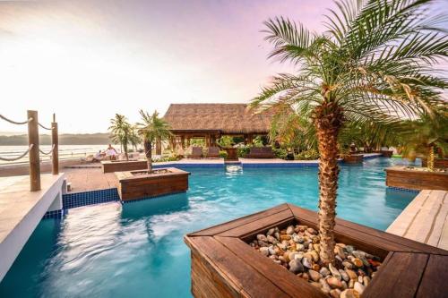普拉纳维瑙LUXURY Apartment in BLUE Playa Venao D-32的棕榈树游泳池和度假村