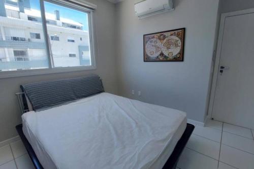 弗洛里亚诺波利斯Apartamento Safira / Praia dos ingleses的一间带床的卧室,位于带窗户的房间内