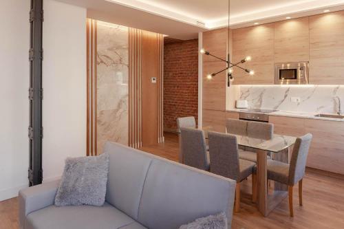 马德里NEW, Modern and Luxurious, 3BR Apt的一间带桌子和沙发的用餐室