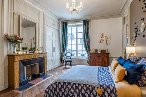 里昂Appartement Haussmannien d’Artiste, exception, quai de Saône balcon+Parking的一间卧室配有一张床和一个壁炉