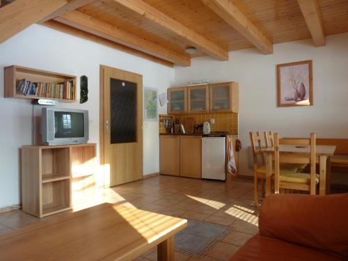 MorávkaA&B布格罗维度假屋的厨房以及带桌子和电视的客厅。