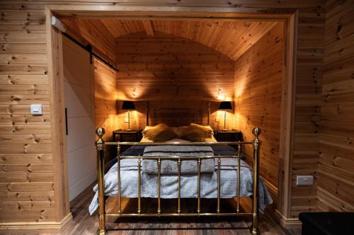 邓加文The Hen Harrier - 4 Person Luxury Glamping Cabin的木墙客房的一张床位