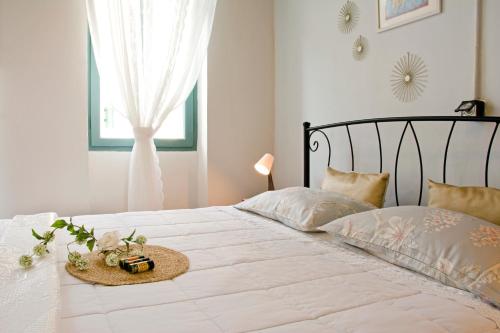 干尼亚Lilian's House的卧室配有白色的床和帽子