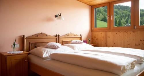 施瓦岑贝格葛莱博生态酒店的带窗户的客房内的2张白色床