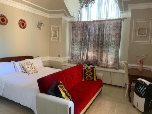 利隆圭Ayonthoo!的一间卧室设有红色的沙发和窗户。