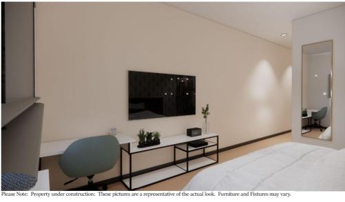普兰菲尔德eStudio Suites的一间卧室配有一张床和一张书桌及电视