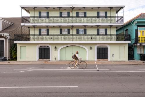 新奥尔良French Quarter Suites Hotel的骑着自行车沿着建筑前的街道骑行的人