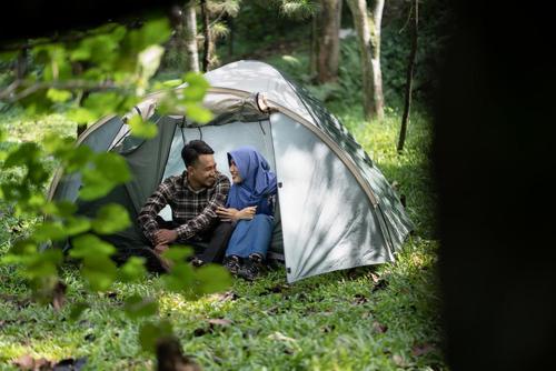 BedahuluPutu Ubud Glamping Camping的坐在帐篷里的男人和女人