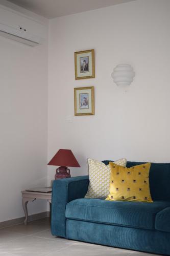 利马索尔T&L Apartments Agiaos Tychonas的客厅配有一张蓝色的沙发,配有一张桌子