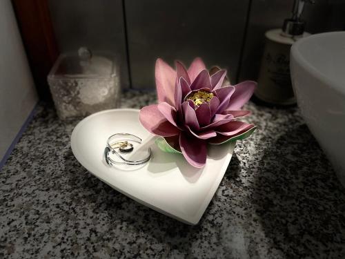 根尼斯迪亚斯Marta Guest House的白色心形水槽中的粉红色花