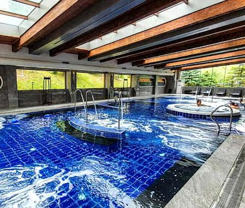 班斯科6 Luxury SPA Apartments TOP resort Bansko - incl wellness的大型游泳池设有两个热水浴池