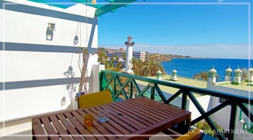 马斯帕洛马斯Ocean Apartment Gran Canaria的阳台设有木桌,享有海景。