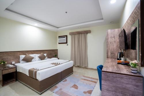 麦加فندق سما سول للشقق的酒店客房设有一张大床和一张书桌。