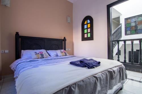 马拉喀什RIAD TAWSALANE的一间卧室配有一张带蓝色床单的床和一扇窗户。