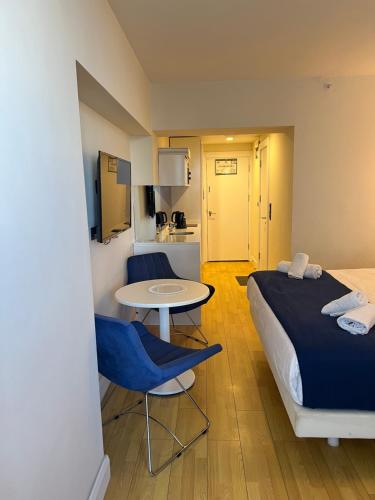 巴统Sea views apartments In Batumi的酒店客房带一张床、一张桌子和椅子