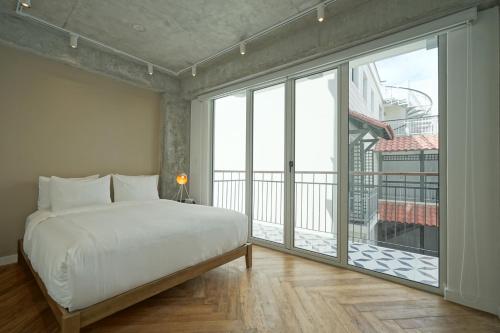 巴拿马城Casa Contemporánea by Wynwood House的一间卧室设有一张床和一个大窗户