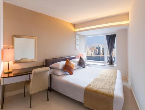 香港九龙海湾酒店的配有一张床、一张书桌和一扇窗户的酒店客房