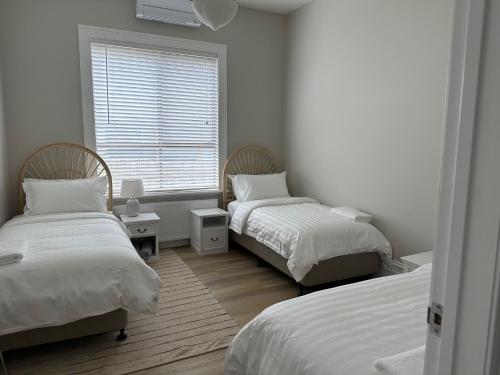 墨尔本Rodonia - Cottage in Kew的一间卧室设有两张床和窗户。