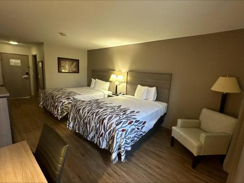 沃基根沃基根红屋顶客栈的酒店客房,配有两张床和椅子