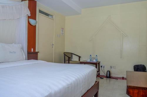 内罗毕Blue Hut Hotel的卧室配有一张白色大床