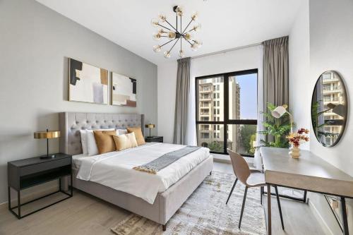 迪拜Silkhaus newly furnished 1BDR next to Burj Al Arab的一间卧室配有一张床、一张书桌和一个窗户。