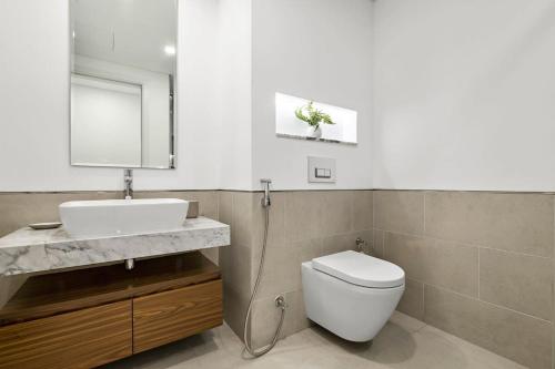 迪拜Silkhaus newly furnished 1BDR next to Burj Al Arab的一间带卫生间、水槽和镜子的浴室