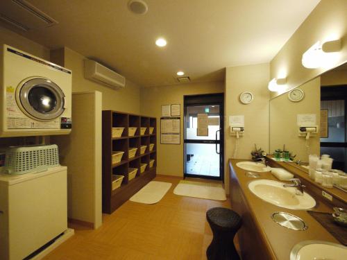 冰见市格兰蒂亚冰见和藏之宿路线酒店的一间带两个盥洗盆和洗衣机的浴室