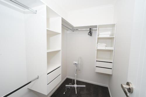 汉密尔顿Charming 4bds House with 3 bathrooms Brand New的一间白色墙壁和白色架子的浴室