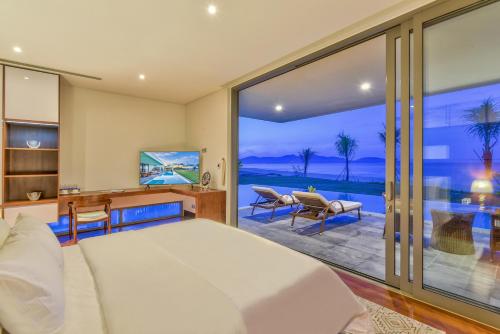 岘港Dreamy Beach Villas And Resort的一间卧室配有一张床,享有海景