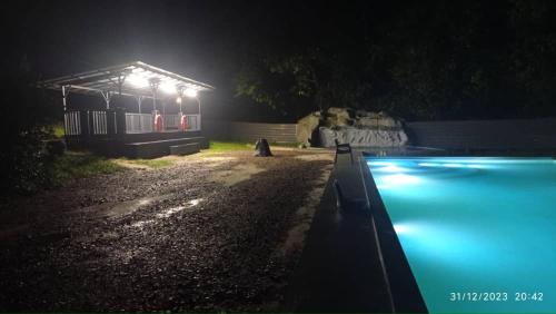 居銮Talula Hill Farm Resort的一座游泳池,晚上有灯光,